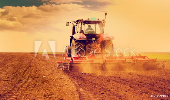 Afbeeldingen van Farmer in tractor preparing land for sowing